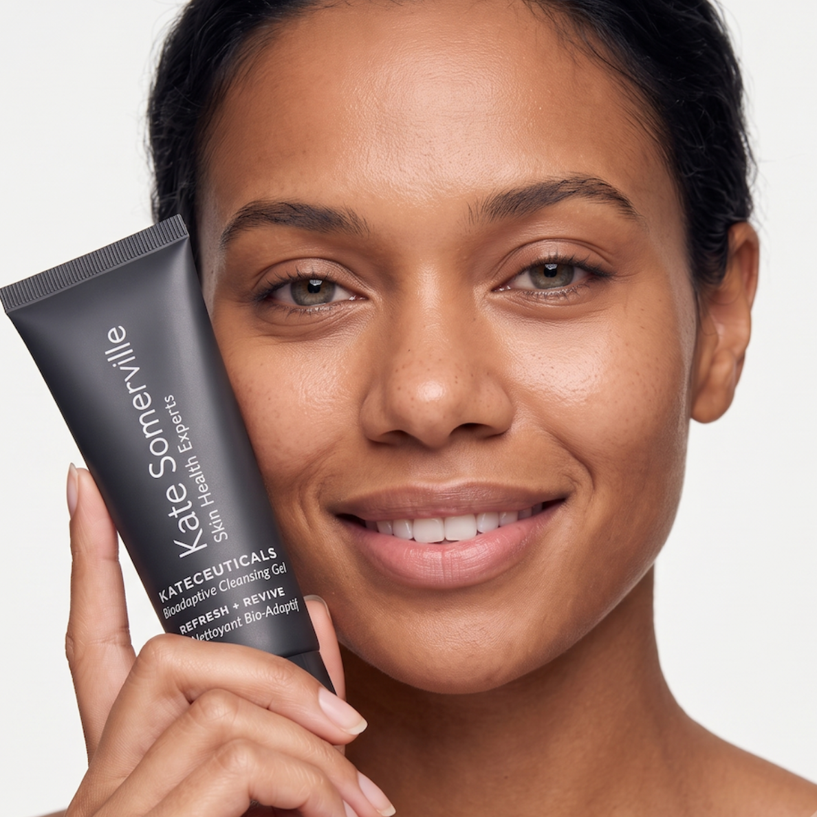 A woman holding a black tube of Kate Somerville K-Bevauticals Hyalu-Cuticals Retinol Cream against a clean white background.